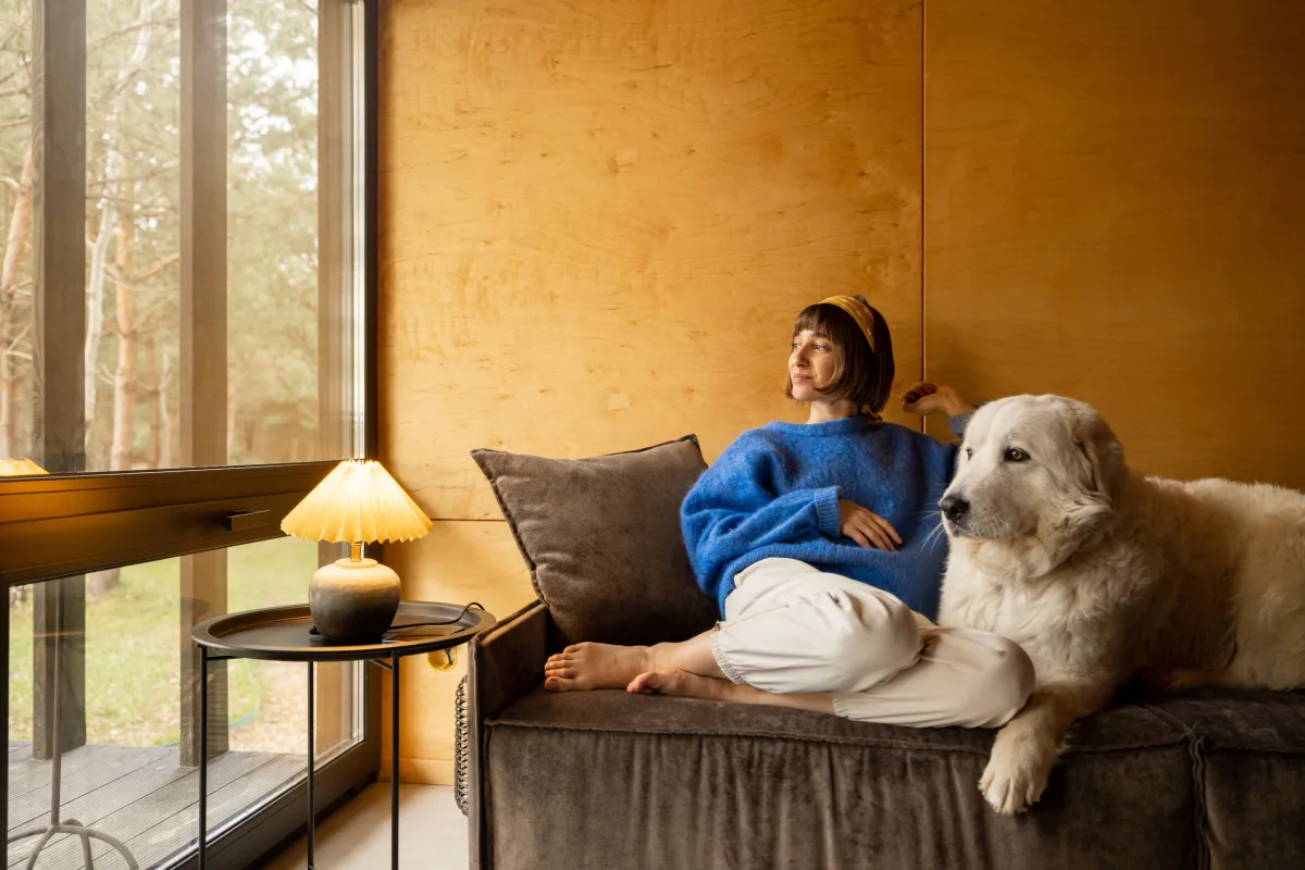 woman sitting on a couch with a dog