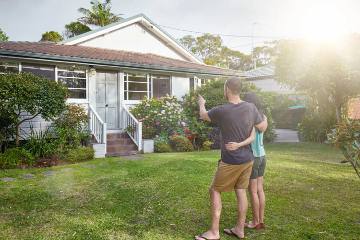 couple standing in front of house looking in